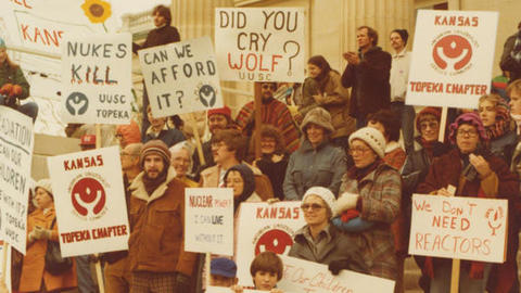 Unitarian Universalists standing on steps with protest signs.
